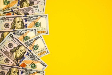 Renkli arka planda 100 dolarlık banknotlar. Metin işi para konseptin için boş bir yer. Sarı arka planda Amerikan doları nakit.