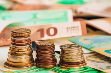 Euro coins on banknote money background, a coin on the background of stacks of coins and banknotes