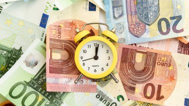 Alarm clock with paper euro money 10, 20, 50, 100, alarm clock on banknotes, Time is money, Time to make money. Alarm clock and dollars, Clock standing on the money