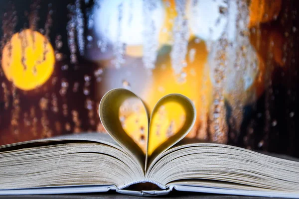 Book with love symbol isolated on window background, Love books, love to read, love stories, heart shape from paper book, Romantic background with the book