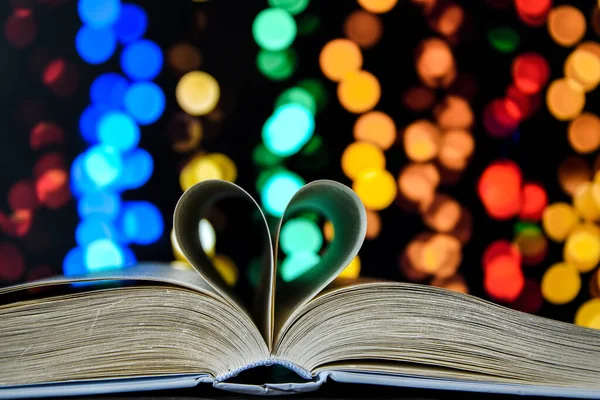 Book with love symbol isolated on bokeh background, Love books, love to read, love stories, heart shape from paper book, Romantic background with the book