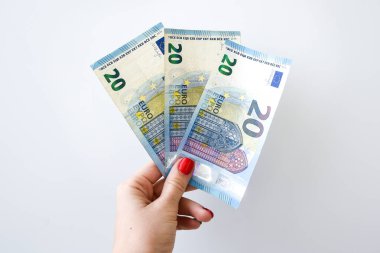 Beyaz arka planda 20 avroluk parası olan bir kadın, yazı için fotokopi alanı, beyaz arka planda izole edilmiş 20 avroluk banknotları sayarak kadınların ellerini kapat.