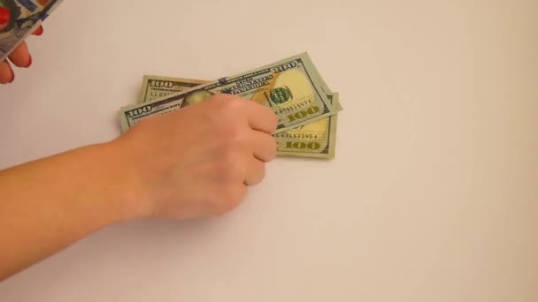 Het Meisje Overweegt Een Pakje Dollarbiljetten Een Witte Tafel Close — Stockvideo