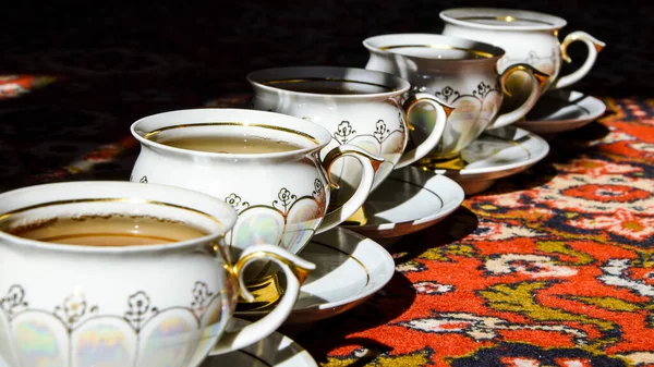 土耳其地毯上有茶托的老式苏打茶杯，传统的茶道，阳光 — 图库照片