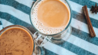 Büyük bardakta sütlü buzlu kahve, bir fincan lezzetli frappe kahve, latte machiato, tarçın çubuklu iki fincan kapuçino ve anason yıldızları.