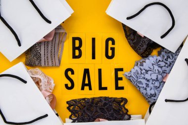 Paketleme çantaları, mesajlaşma Sarı arka planda büyük indirim. Üst görünümde düz görünüm satışı, perakende satış, alışveriş konsepti, kara cuma konsepti.