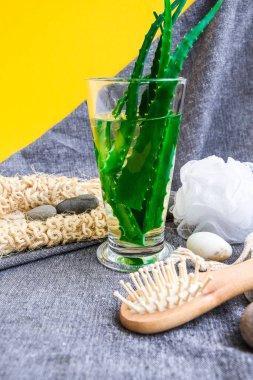 Sarı arka plan, tatil ve sağlıklı yaşam tarzında aloe vera içeceği ile yüz ve vücut tedavileri için kaplıca çevre dostu set seti