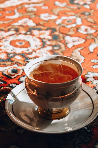 古老的瓷茶时间在土耳其地毯上 红茶在瓷杯中烟熏 茶碟在阳光下 亚洲茶道 热蒸汽 — 图库照片