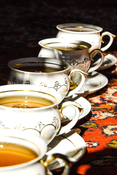 土耳其地毯上有茶托的老式苏格兰人茶杯 传统的茶道 有深深阴影的阳光 — 图库照片