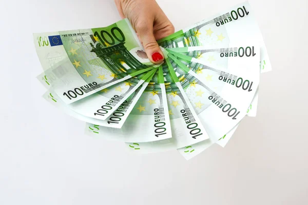 Euro bills in female hands. Euro cash background on white, fan of 100 euros, one hundred euros