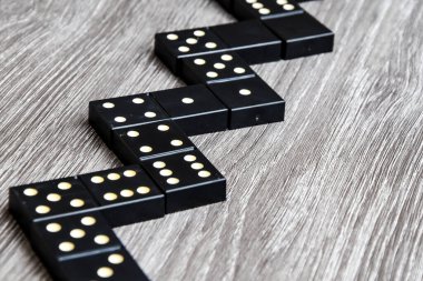 Siyah Domino zarları açık tahta bir masada, domino oynama süreci, seçici odaklanma, yakın plan, masa oyunu