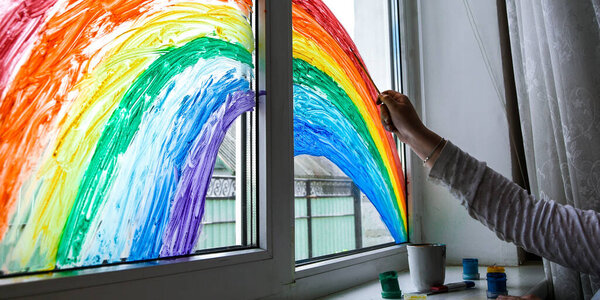hand painting rainbow on a window, stay home during quarantine, Image of kids leisure at home, Chase the rainbow flashmob