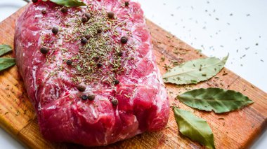 Çiğ domuz omuzu ve baharat. Koyu yaprak, ahşap arka planda, kapak, baharatlı taze çiğ et, fileto, kürek, boyun, arka bacak bifteği üzerine siyah biber