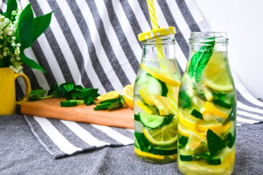Limonata, dilimlenmiş limon ve salatalıklı mojito, kesme tahtasında nane yaprağı, ferahlatıcı yaz arınma içecekleri, seçici odak, vadinin zambağı.