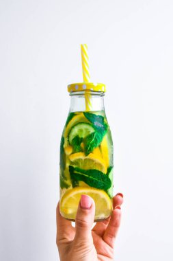 Taze soğuk limon salatalığı, nane şekeri, taze su arıtma içeceği, yaz ferahlatıcı içecek, organik vegan içecek, kadın eli.