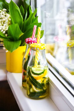 Limonata, limon ve salatalık, pencere kenarındaki nane yaprakları, yaz ferahlatıcı detoks içecekleri, seçici odak, vadideki zambak çiçeği.