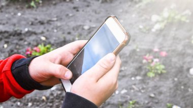 Akıllı telefonu olan küçük bir çocuk yeni teknolojilerde ustalaşıyor, fotoğraf çekiyor, küçük fotoğrafçı, seçici odaklı.