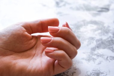 Pembe renkte güzel doğal çivi jölesi, beyaz manikürlü eller, metin için kopya alanı