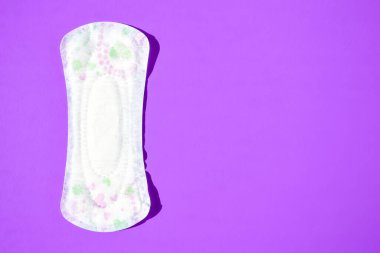 Mor arka planda hijyenik ped, kadın hijyen koruması için regl bezi. Kritik günler. Tıbbi kavram, metin için kopyalama alanı