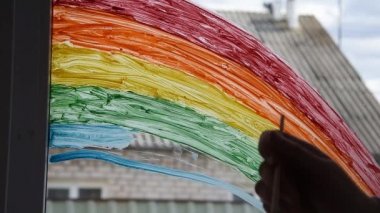 Evde Covid-19 karantinası sırasında gökkuşağı boyamak. Coronavirus önleme için sosyal medya kampanyasında evde kal, hepimiz iyi olalım.