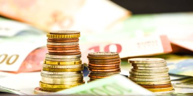 Euro coins on banknote money background, a coin on the background of stacks of coins and banknotes