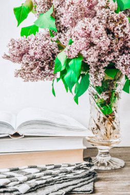 Cam vazoda leylak çiçeği buketi. İp ve kitaplarla dolu. Fotokopi alanı.