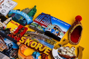 Sarı arka planda farklı ülkelerden mıknatıslar, seyahat konsepti, planlama gezisi