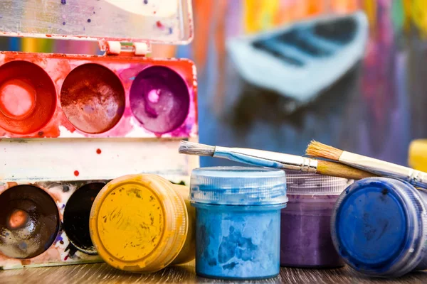 A set of paints for body painting. workplace, Paints, brushes and palette on the colorful background. The workplace of the artist. Banner for school