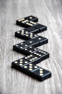 Siyah Domino zarları açık tahta bir masada, domino oynama süreci, seçici odaklanma, yakın plan, masa oyunu