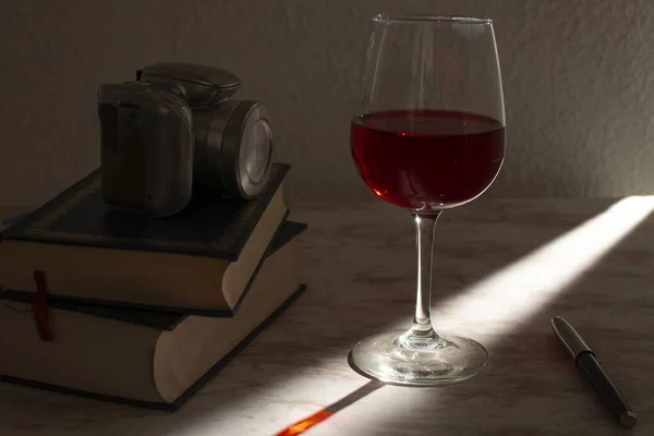 Copa Vino Acompanada Unos Libros Una Cámara Fotográfica Con Luz —  Fotos de Stock