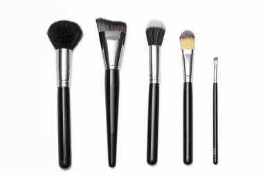 Brochas de maquillaje acomodadas de manera estetica sobre un fondo blanco
