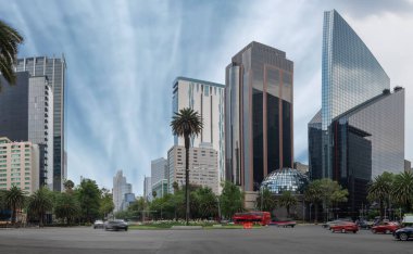 Mexico City 'nin binaları Avenida Reforma' nın kavşağında. Mavi gökyüzü ve yarı boş sokakları var.