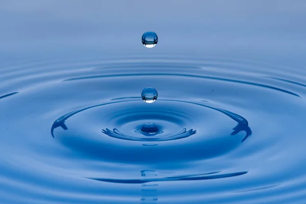 Синьо Фіолетові Краплі Води Підвішені Повітрі Утворюють Брижі Рідкій Поверхні — стокове фото