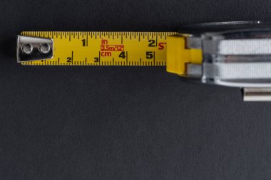 Siyah zemin üzerinde sarı bant ölçüsü olan frakometre ya da metre gümüş rengi