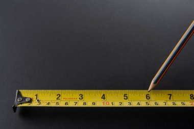 Siyah zemin üzerinde sarı bant ölçüsü olan frakometre ya da metre gümüş rengi