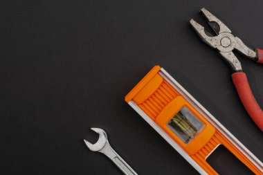 Seviye, pense ve anahtar siyah bir arkaplanda düzenlenmiştir