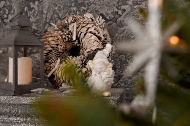 İçinde mum, Noel çelengi ve diğer Noel süslemeleri olan gri gözlüklerle modern bir iç mekan. Bulanık arkaplan ve kopyalama alanı.