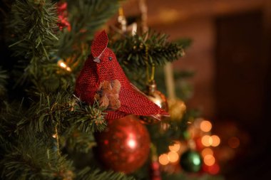 Güzel bir Noel ağacı, güzel parlak toplar ve kırmızı kuş oyuncaklarıyla süslenmiş. Sihirli bulanık arkaplan ve kopyalama alanı.