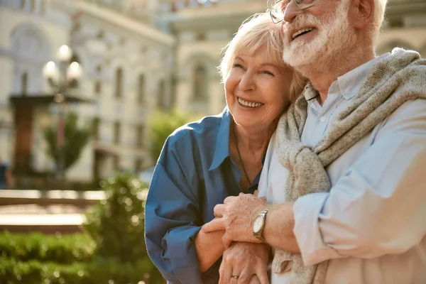 Immer zusammen. Glückliches Senioren-Paar verbindet sich und lächelt, während es Zeit zusammen im Freien verbringt — Stockfoto