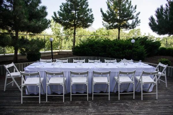 Fehér Szolgált Asztal Sok Székkel Szabadban Háttérben Zöld Fák — Stock Fotó