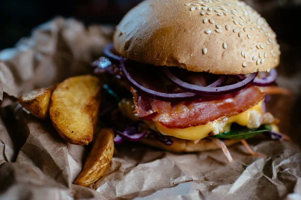 Siyah arkaplanda sığır etli burger.