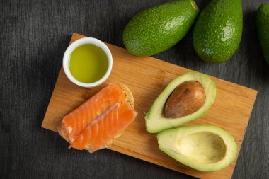 Ekmek dilimleri üzerine somon. Avokado ile meze. Taze somon ve avokado sandviçi. Sağlıklı gıda konsepti. Avokado ve somonla kahvaltı..