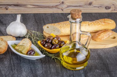 Zeytinyağına batırılmış zeytinyağlı ekmek. Yunan zeytinyağlı ekmek sosu. Beyaz kasede Yunan sosu ve ahşap arka planda Yunan zeytinleri. Zeytinyağı ve baharatlar. Ekmek batırma kavramı.