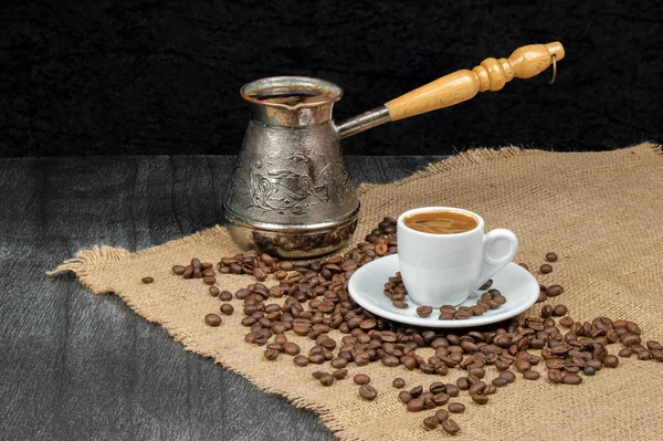 Beyaz fincanda Yunan kahvesi ve klasik kahve demliği. Ahşap zemin üzerinde fasulye olan Türk kahve fincanı. Kahve kültürü, geleneksel konsept. Metin için alanı kopyala.