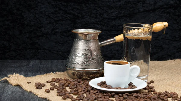 Kahve Cooper ve keten masa. Yunan Kahve Tenceresi, bir bardak su ve fasulye ahşap masaya düştü. Beyaz kahve fincanı. Uzayı metin için kopyala. Geleneksel Yunan Kahve Konsepti.