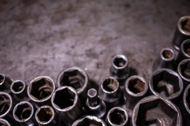 Metal arka plana mekanik aletler yerleştirildi. Metal üzerindeki boşluğun klasik görüntüsü, bir sürü eski alet. Uzayı kopyala Araba servisi ve tamir konsepti. Çalışma masasında araçlar.