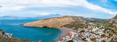 Matala Panoraması, Girit adasındaki güzel plaj, dalgalar ve kayalar. Mağaraları ve mavi gökyüzü olan Matala köyü. Matala, Girit.