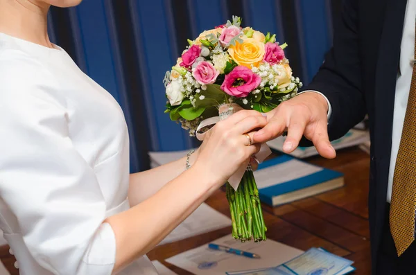 Recién casados intercambian anillos, el novio pone el anillo en la mano de la novia en la oficina del registro matrimonial — Foto de Stock