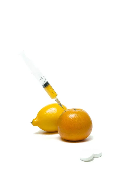 Vitamine und Pillen zur Behandlung von Erkältung und Grippe. Zitrone, Spritze, Kirsche. Pille im Fokus. — Stockfoto