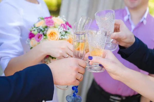 Οι επισκέπτες στο γάμο με τη νύφη και το γαμπρό τσουγκρίζουν τα ποτήρια σαμπάνιας — Φωτογραφία Αρχείου